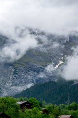 Wooden house infront of high cloudyy mountain, Switzerland Alps