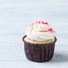 Delicious birthday cupcake with red-white cream.