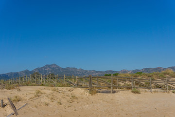 Surfing beach with dunes and mountains in the background