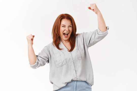 Oh yeah mothers rule. Empowered encouraged good-looking satisfied lucky middle-aged redhead woman lift hands satisfaction success celebrating achievement triumphing clenched fists yeah win
