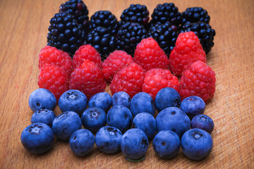 Background of fresh fruits and berries. Ripe blackberries, blueberries, plums, raspberries. Mix berries and fruits. Top view. Background berries and fruits. Black-blue and red food.