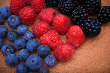 Background of fresh fruits and berries. Ripe blackberries, blueberries, plums, raspberries. Mix berries and fruits. Top view. Background berries and fruits. Black-blue and red food.