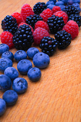Background of fresh fruits and berries. Ripe blackberries, blueberries, plums, raspberries. Mix berries and fruits. Top view. Background berries and fruits. Black-blue and red food.