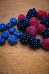 Background of fresh fruits and berries. Ripe blackberries, blueberries, plums, raspberries. Mix berries and fruits. Top view. Background berries and fruits. Black-blue and red food.