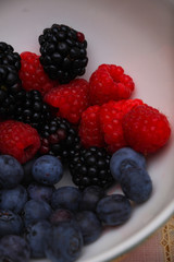 Background of fresh fruits and berries. Ripe blackberries, blueberries, plums, raspberries. Mix berries and fruits. Top view. Background berries and fruits. Black-blue and red food.