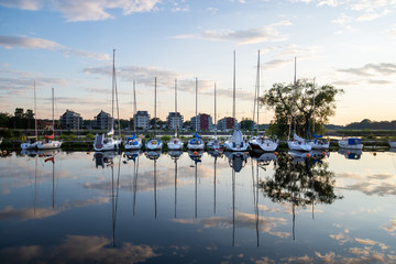 Boats in small town harbour reflection