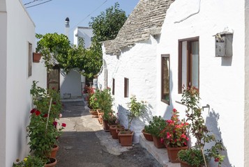ALBEROBELLO, ITALY - AUGUSt 27 2017: Exterior of a traditional trullo house in Italy, with flowers around