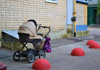 baby stroller with a package is one, next to the red concrete blocks
