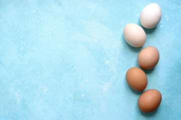 White and beige raw chicken eggs. Top view with copy space.