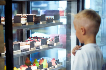 little boy chooses goods in a cafe