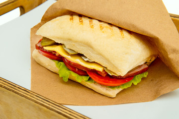 Fresh submarine sandwiches with ham, cheese, bacon, tomatoes, lettuce, cucumbers and onions. Ciabatta sandwich.