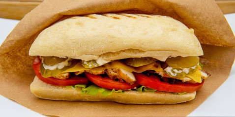 Fresh submarine sandwiches with ham, cheese, bacon, tomatoes, lettuce, cucumbers and onions. Ciabatta sandwich.