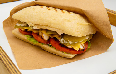 Fresh submarine sandwiches with ham, cheese, bacon, tomatoes, lettuce, cucumbers and onions. Ciabatta sandwich.