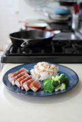 Ahi tuna sliced thin with teriyaki demi-glace, served with rice and broccoli.