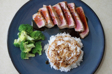 Ahi tuna sliced thin with teriyaki demi-glace, served with rice and broccoli.