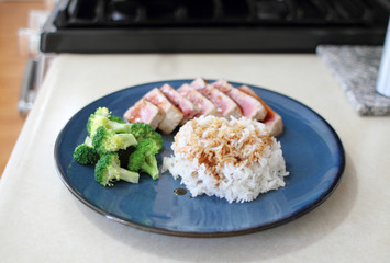 Ahi tuna sliced thin with teriyaki demi-glace, served with rice and broccoli.
