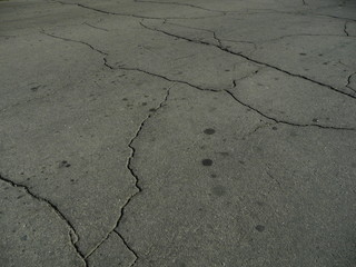 Obraz premium The asphalt is covered in cracks from poor quality work.