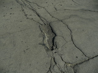 Asphalt. All in holes and cracks.