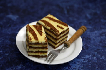 Two pieces of striped cake on a plate. Black-white cake. Dessert Zebra. Selective focus. macro.