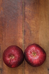 view from above flat lay photo of red apple fruit on brown wooden background
