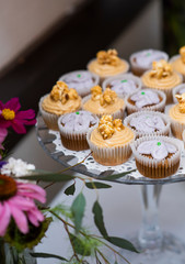dessert table at wedding, gourmet cupcakes at an event, assortment of cup cakes on tiered platter, platter of baked goods