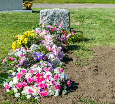 bright beautiful flower bouquets at a gravesite after a funeral