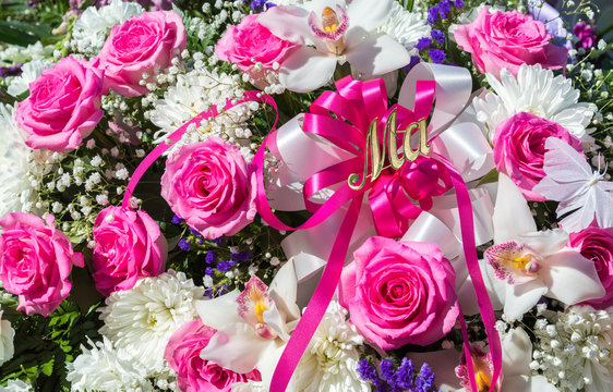 close up of a pink and white funeral bouquet with the word Ma