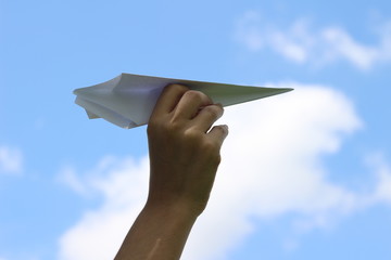 Hand holding paper airplane