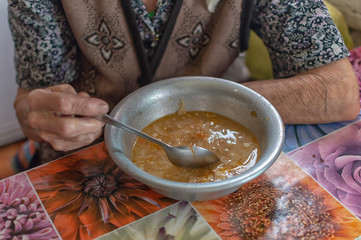 The old woman eats soup, charity food for the poor pensioners, social reform