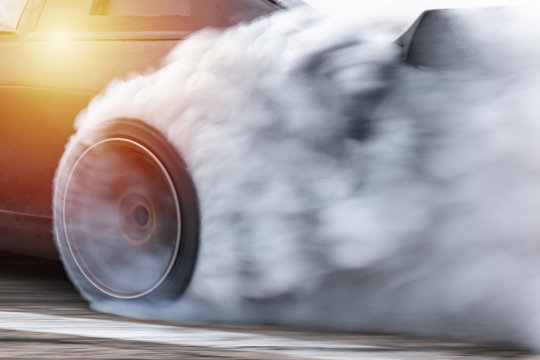 Car drifting, Blurred  image diffusion race drift car with lots of smoke from burning tires on speed track.