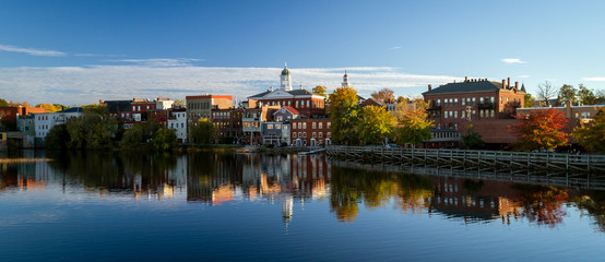 The river front buildings of Exeter, New Hampshire are seen reflected in the water - obrazy, fototapety, plakaty