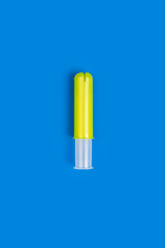 Empty Yellow Plastic Tampon Applicator Isolated On Vivid Blue Background