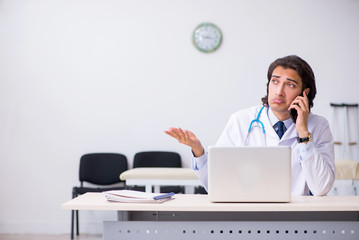 Young handsome doctor in telemedicine concept