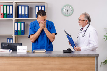 Two doctors talking at the reception in hospital