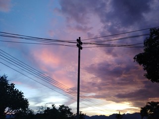 silhouette of electric wires against blue sky