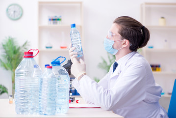 Fototapeta premium Young male chemist experimenting in lab