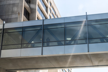 Skywalk bridge made of steel and glass between corporate office buildings in midtown or downtown of Atlanta, Georgia city with people walking