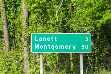 Road sign for mile distance to Lanett and Montgomery city in Alabama along interstate highway i-85...