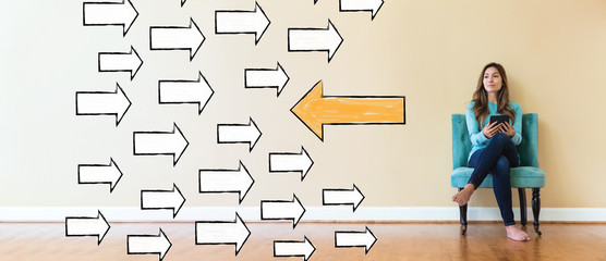 Arrow going in a opposite direction with young woman holding a tablet computer