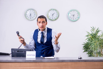 Young man receptionist at the hotel counter