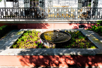 Old street historic Garden district in Louisiana city with garden water fountain by house patio or...
