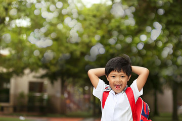 An Asian young boy with school uniform getting excited and cheerful when coming back to school.