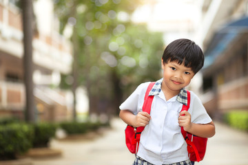 An Asian young boy with school uniform getting excited and cheerful when coming back to school.