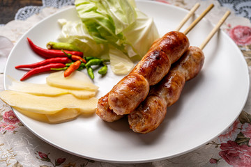 Northeastern Sausage , Isan pork sausage recipe , Isaan pork sausage recipe on a white plate with a side dish