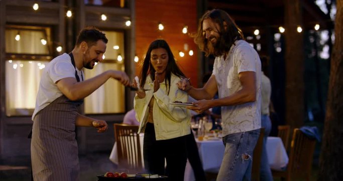 Large diverse group of friends people enjoying backyard barbecue party together, summertime outdoors lifestyle. 4K UHD