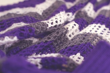 Purple and white striped pattern crochet sweater. Texture detail close up.