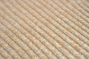 Mottled beige knitted sweater. Texture detail close up.
