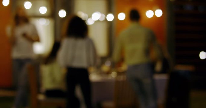 DEFOCUSED BACKGROUND Large diverse group of friends people enjoying backyard barbecue party together, summertime outdoors lifestyle. 4K UHD