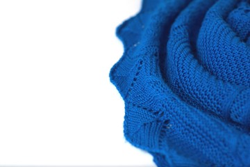Azure blue crochet sweater on white background. Texture detail close up.