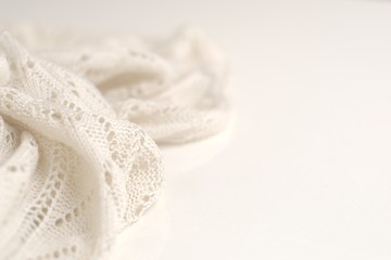 Obraz na płótnie Canvas Ivory color crochet sweater on white background. Texture detail close up.